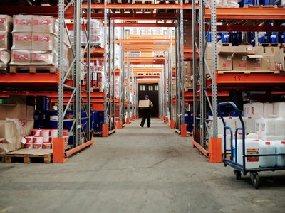 warehouse full of packages and a man carrying a box
